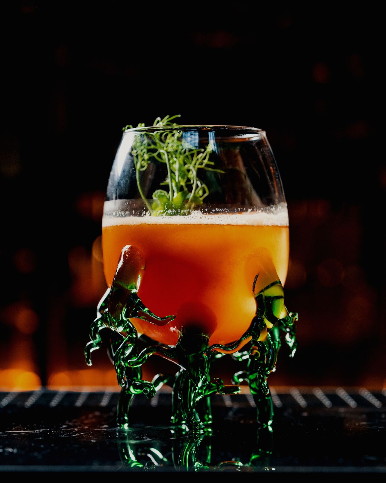An amber cocktail in a sculpted glass