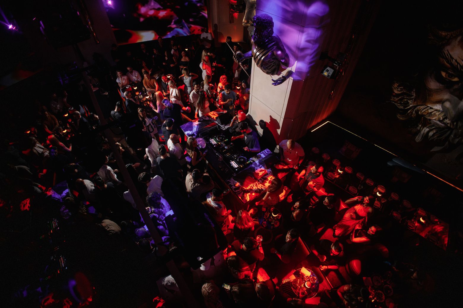 The dancefloor from above: the DJ, the bronze Zeus on his column, red and violet light