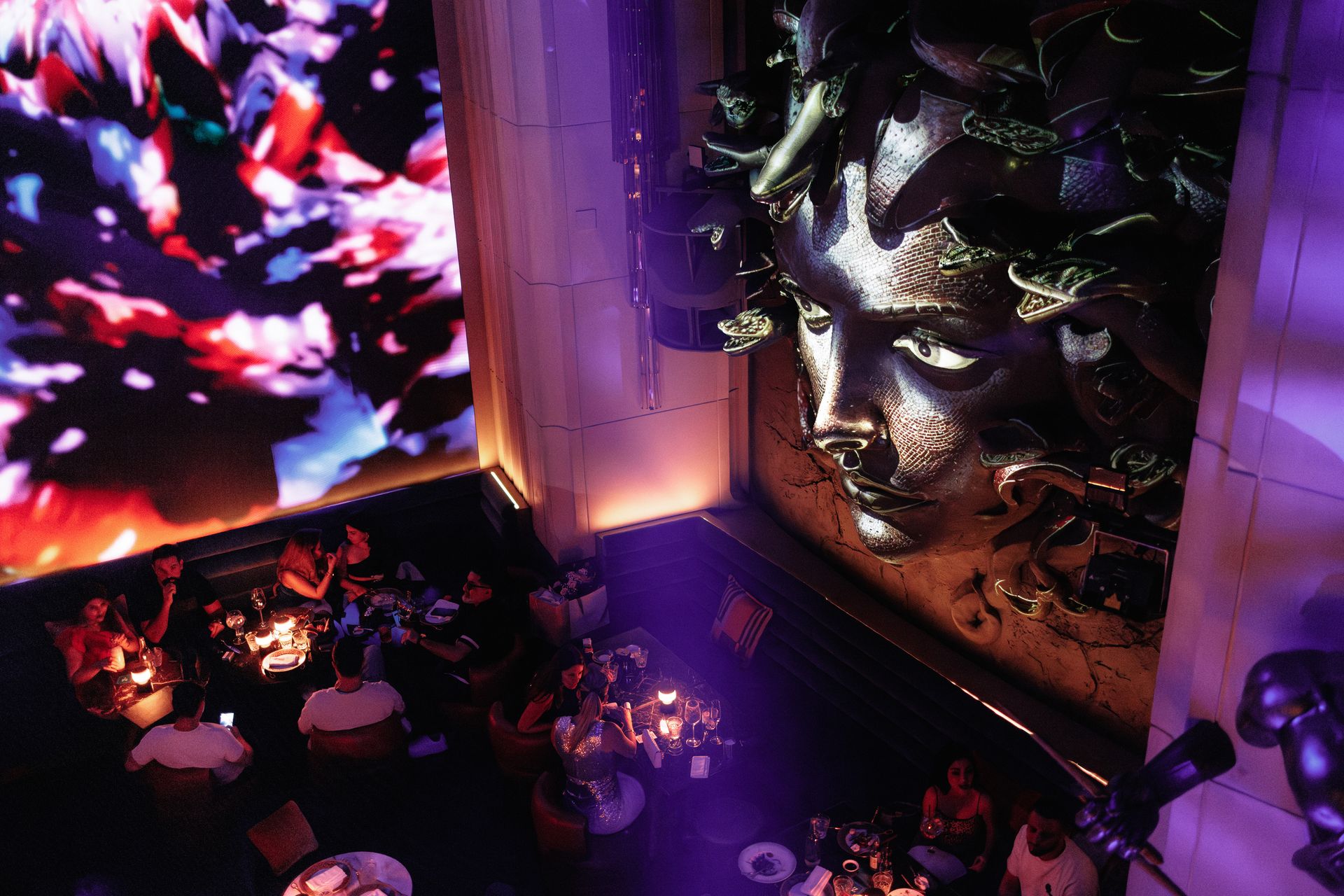 The bronze Medusa above the tables, violet light